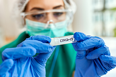 closeup epidemiologist with covid19 sample test tube